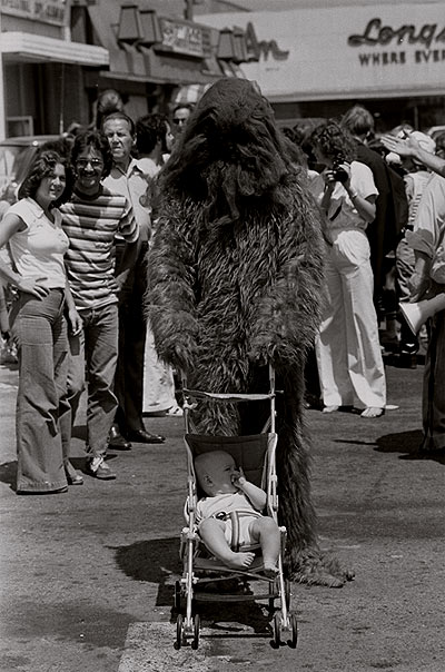 Bret Pardo, wearing a Chewbacca costume, pushing daughter in stroller at movie theatre in North Hollywood, Calif., 1979