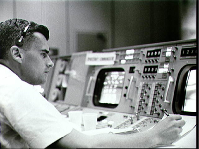 Astronaut Roger B. Chaffee is shown at the consoles in the Mission Control Center - Houston during the Gemini-Titan 3 flight.