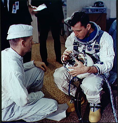 Astronaut John W. Young, pilot of the Gemini-Titan 3 space flight, checks over his helmet during suiting operations in the suiting trailer at Pad 16 prior to flight.