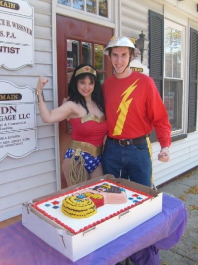Amber as Wonder Woman and Andrew Moser as Jay Garrick/Flash pose with the cake created & donated by a Comic Fusion customer