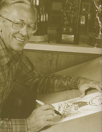 Charles Schulz in his later years with a drawing of Charlie Brown